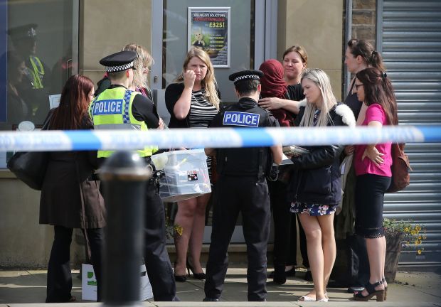 The mum of two was shot and repeatedly stabbed “with a foot long knife” in broad daylight this afternoon as dozens of shocked locals looked on