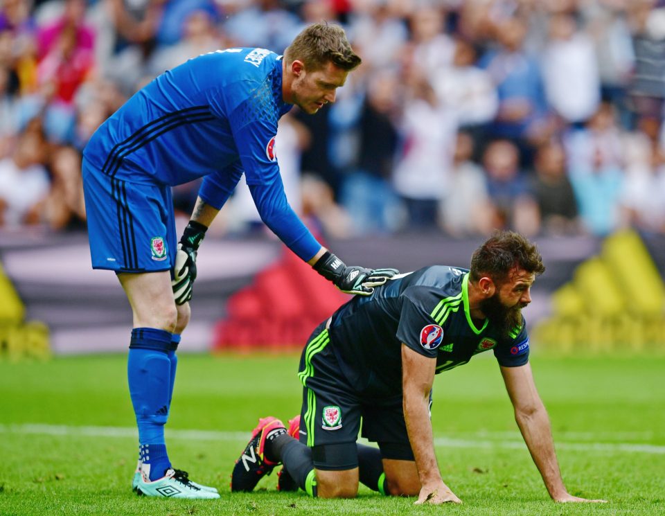  Wayne Hennessey checks to see if Joe Ledley is ok during the match with England