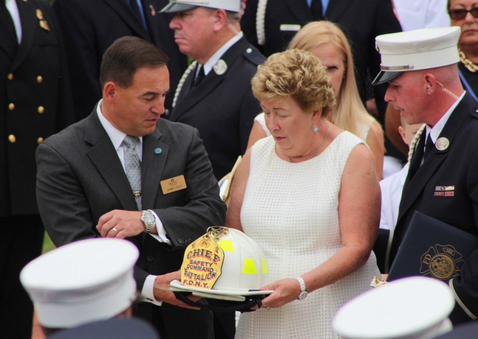 Theresa Stack holds the helmet of her husband who was finally laid to rest on Friday