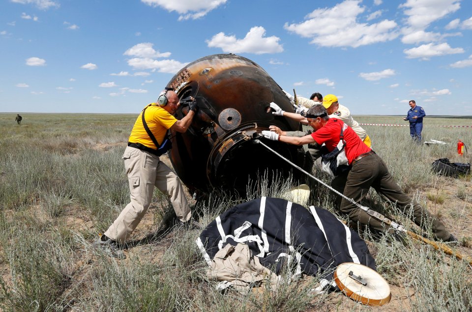 Search and rescue team members roll Soyuz TMA-19M spacecraft capsule carrying ISS crew members Peake of Britain, Malenchenko of Russia and Kopra of U.S. shortly after landing Dzhezkazgan