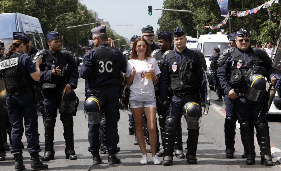 A Poland fan poses with French police