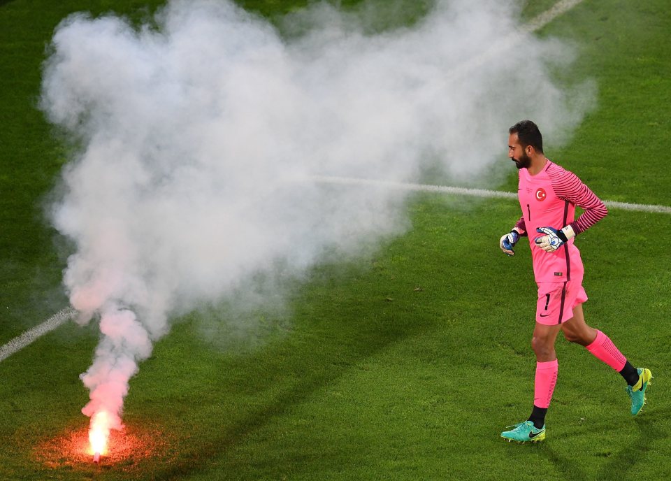  Turkey goalkeeper Volkan Babacan removes a flare thrown onto the pitch