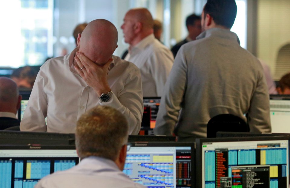  Traders hang their heads in despair at a brokerage company in London's Canary Wharf