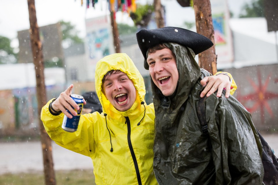 People run for cover during heavy rain in the Hospitality area at Glastonbury Festival, Pilton, Somerset. 24 June 2016. The Glastonbury Festival is a five-day festival of contemporary performing arts that takes place near Pilton, Somerset. In addition to contemporary music, the festival hosts dance, comedy, theatre, circus, cabaret, and other arts