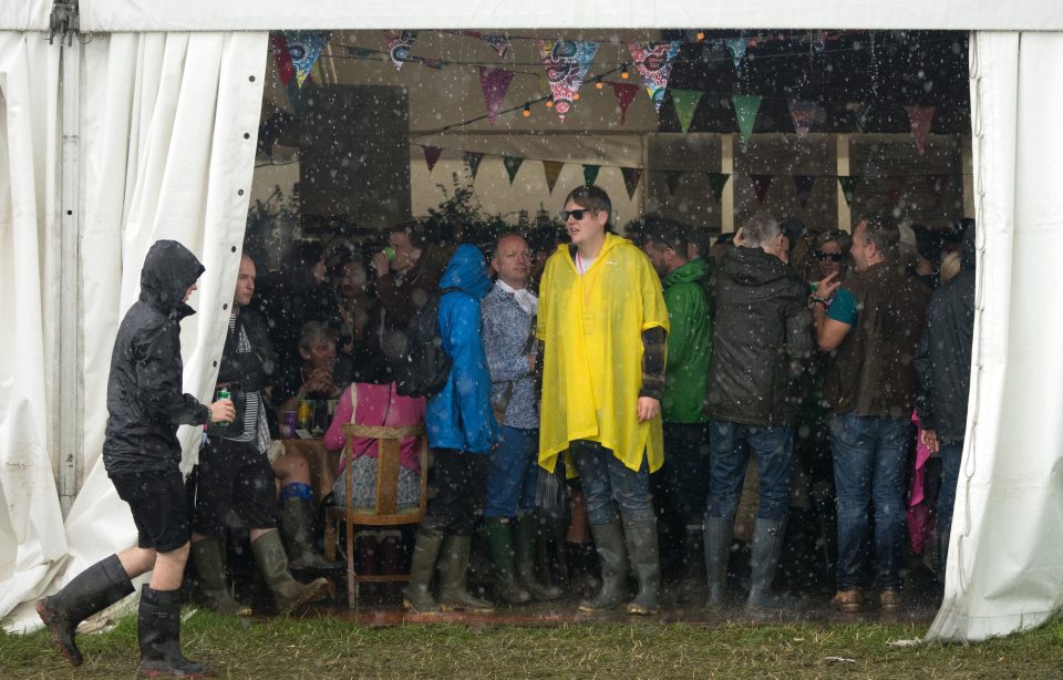 epa05387895 Festival-goers take shelter from the rain during the Glastonbury Festival of Contemporary Performing Arts 2016, held at Worthy Farm, near Pilton, Somerset, Britain, 24 June 2016. The outdoor festival runs from 22 to 26 June. EPA/ANDREW COWIE