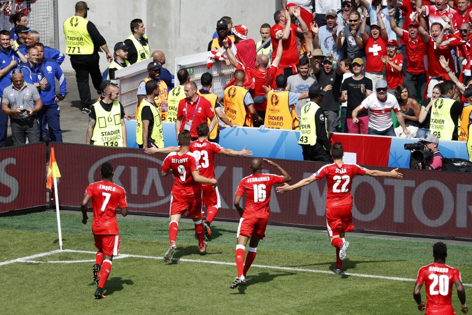  Shaqiri is mobbed by Swiss team-mates after his brilliant goal