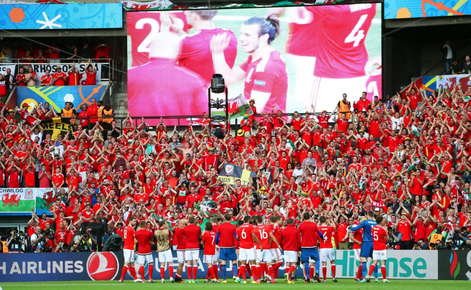  The Welsh squad celebrate with their fans at the final whistle