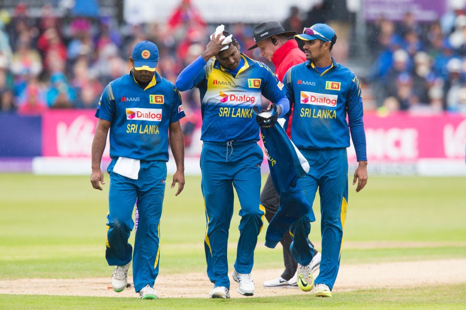  Angelo Mathews wipes away the rain as the teams are forced off by the weather