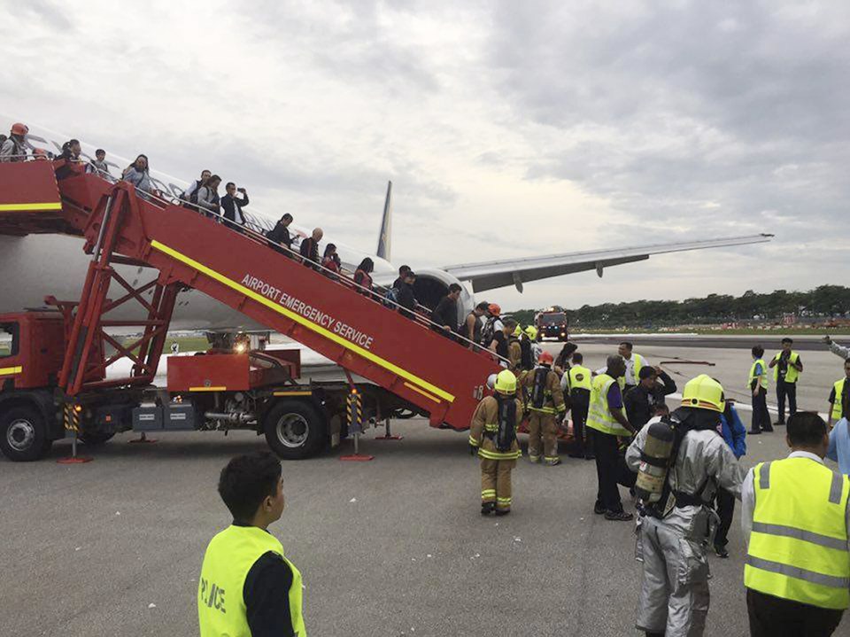  Passengers are led off the plane after spending a nerve-shredding five minutes watching on as firefighters tried to battle the flames