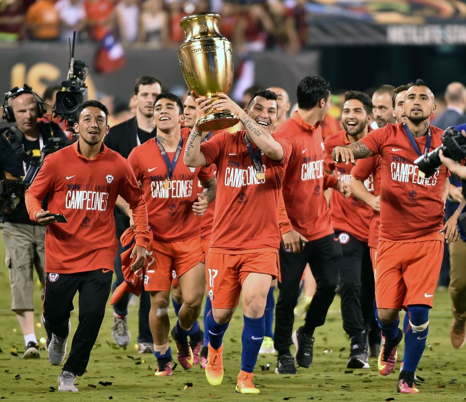 Gary Medel takes the trophy on a lap of honour as his team-mates follow him