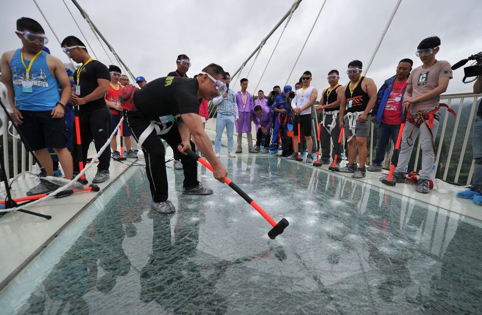  Nerves of steel: Visitors hit a glass-bottomed bridge with sledgehammers as part of 'safety test' in Zhangjiajie city in China's Hunan Province