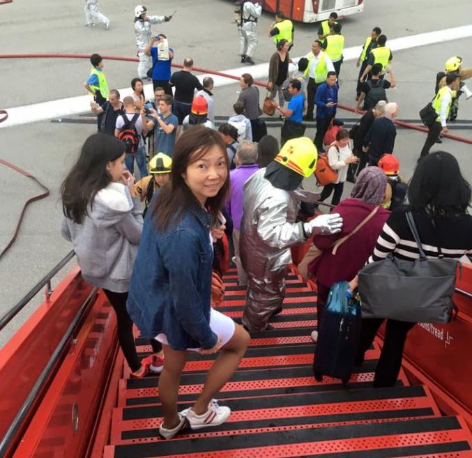 Lee Bee Yee poses for a picture while passengers are evacuated from the Boeing 777 at Changi Airport