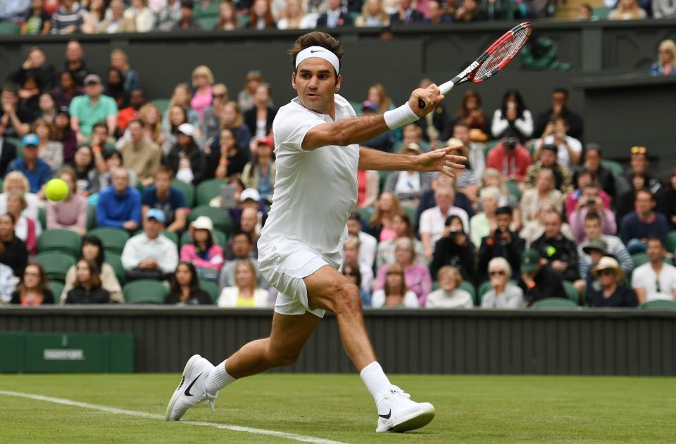  Roger Federer pulls off a trademark backhand during the first round of Wimbledon