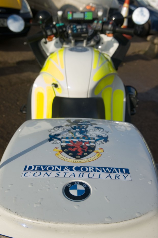 rear view of aDevon and Cornwall police motorbike featuring the coat of arms on the rear pannier. Image shot 02/2007. Exact date unknown.