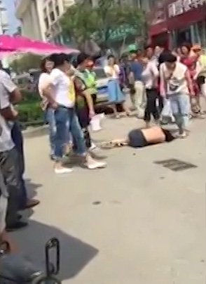  A woman aims a kick at the helpless girl as she lies crying