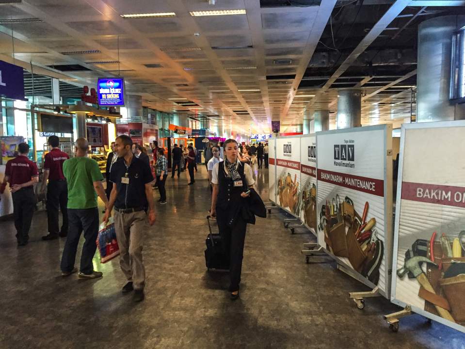  Stewardess walks past a damage area of the airport as flights get back underway