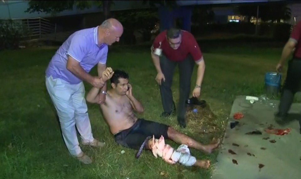  An injured man is helped by passersby after being injured in a triple suicide blast at Istanbul Airport