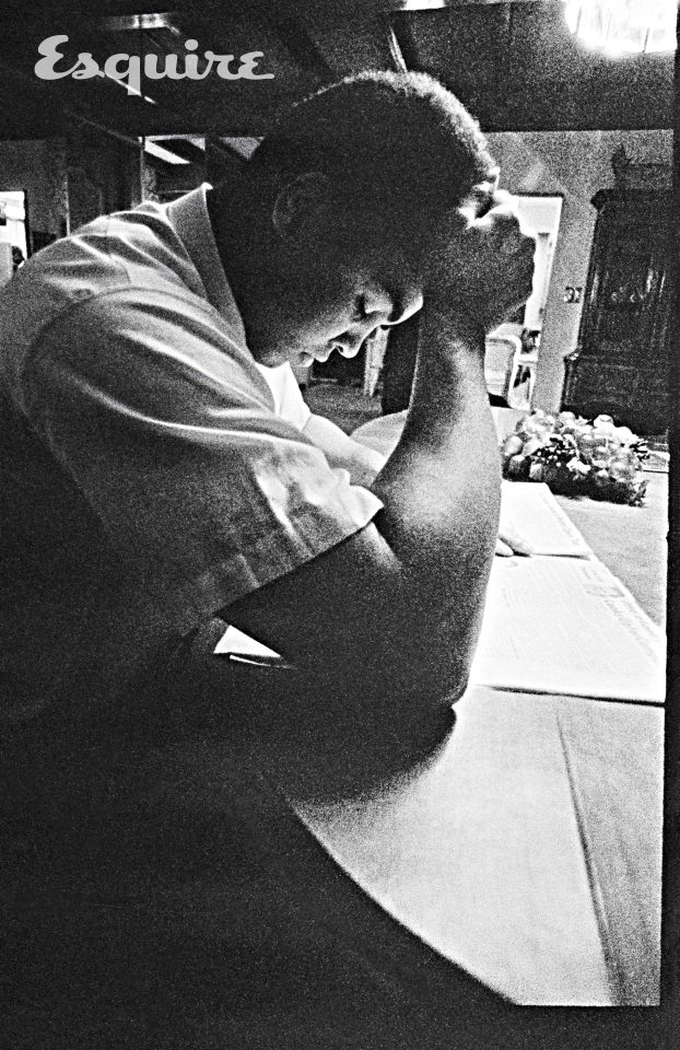  'The Greatest' in a quiet moment as he reads a newspaper at his home