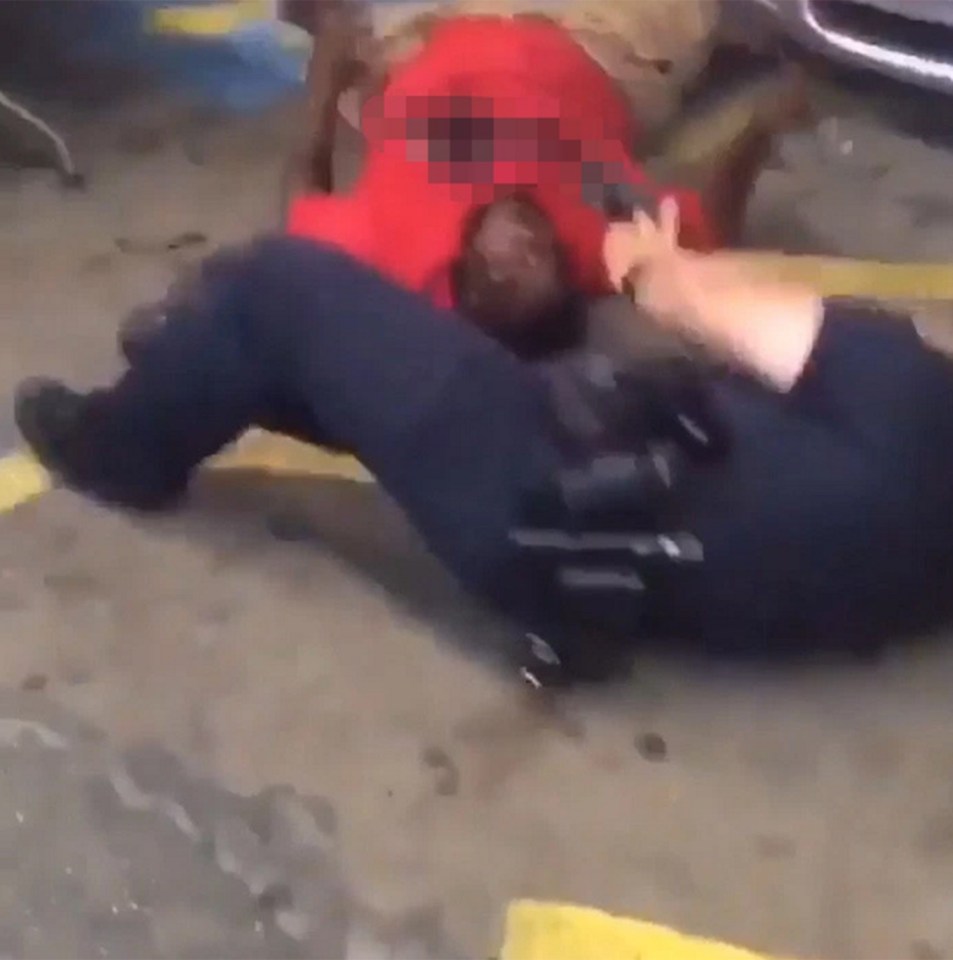 The two officers hold a gun to the chest of Alton Sterling as he is restrained on the pavement outside a Louisiana shop