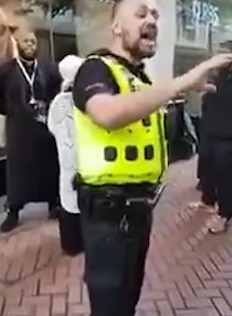  The officer tries to talk to an increasingly irritated crowd