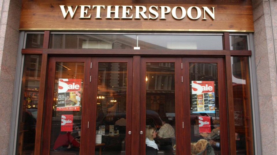 Wetherspoon pub exterior with sale signs in the windows.