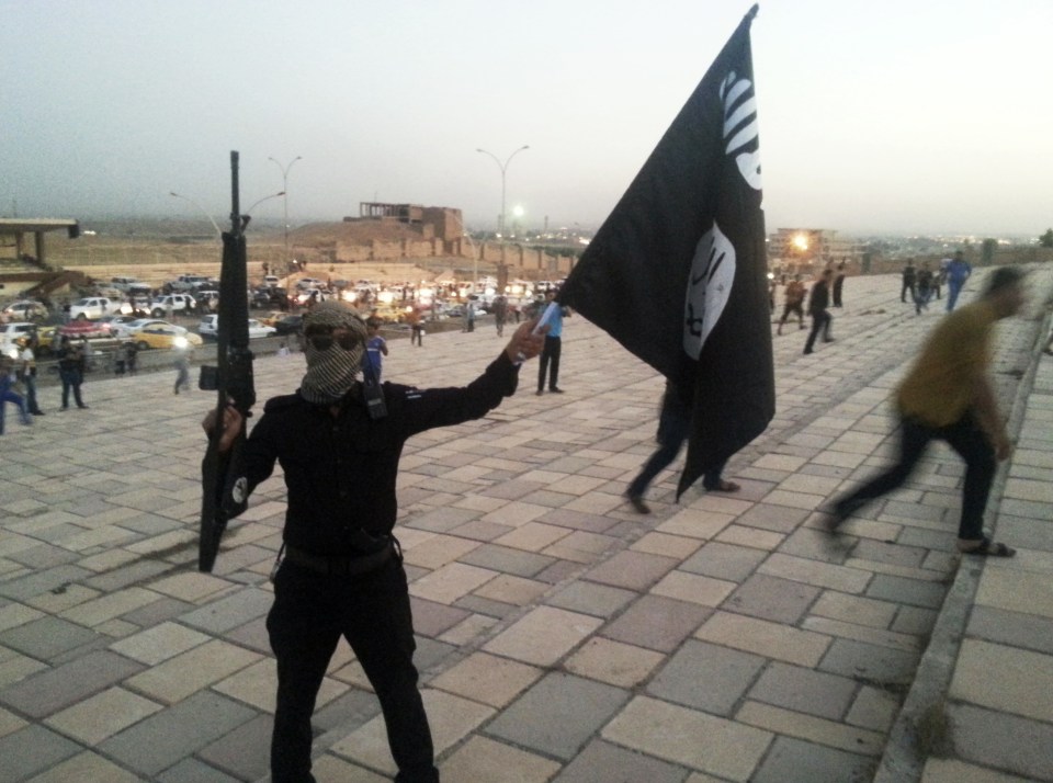  An ISIS fighter waves one of the terror group's flag in Mosul, Iraq