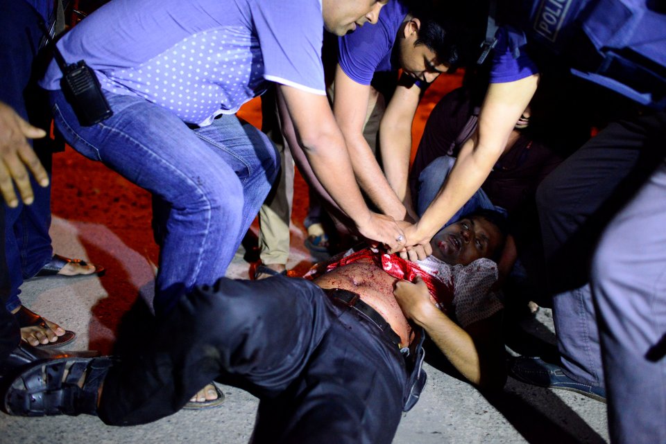 People try to help an injured person, after gunmen stormed the Holey Artisan restaurant and took hostages, in the Gulshan area of Dhaka, Bangladesh