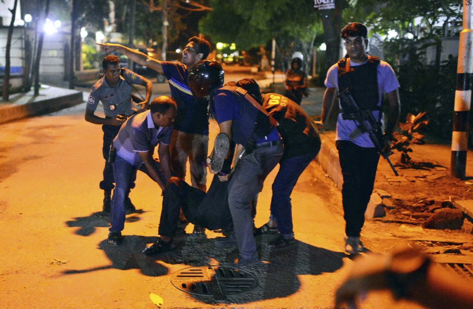  Horror ... People help an injured man the outside Holey Artisan cafe, where 20 people were killed by ISIS militants