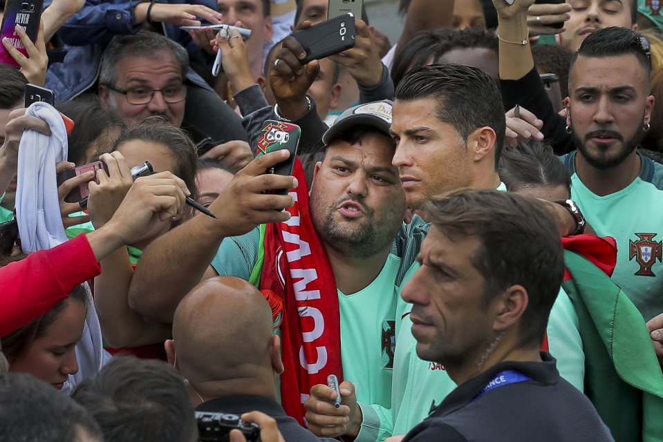  Supporters get up close to Cristiano Ronaldo at the French rugby team's camp in Marcoussis, near Paris. Ron and his team-mates take on Gareth Bale and Co