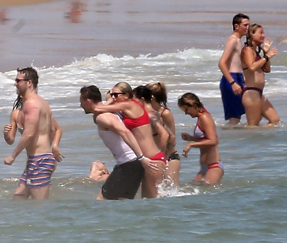  Taylor gets her arms around Tom's neck while in the ocean during their July 4 celebrations