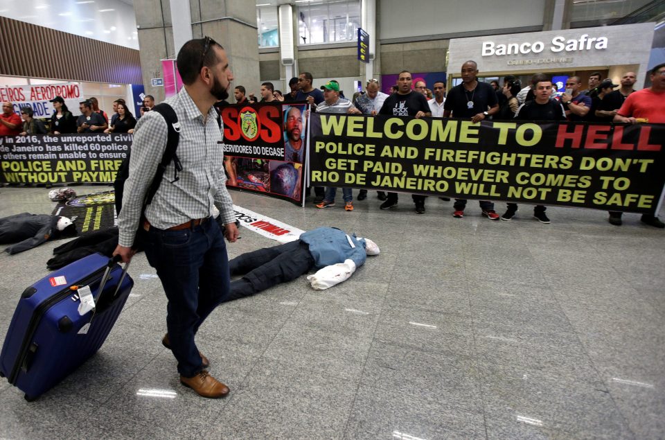 An arriving passenger takes in the police-led protests in the latest chapter of controversy over the Olympics this summer 