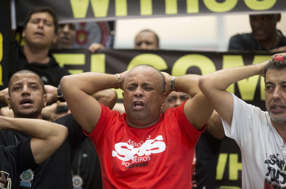 Police officers make a surrender position during a protest about pay and working conditions 