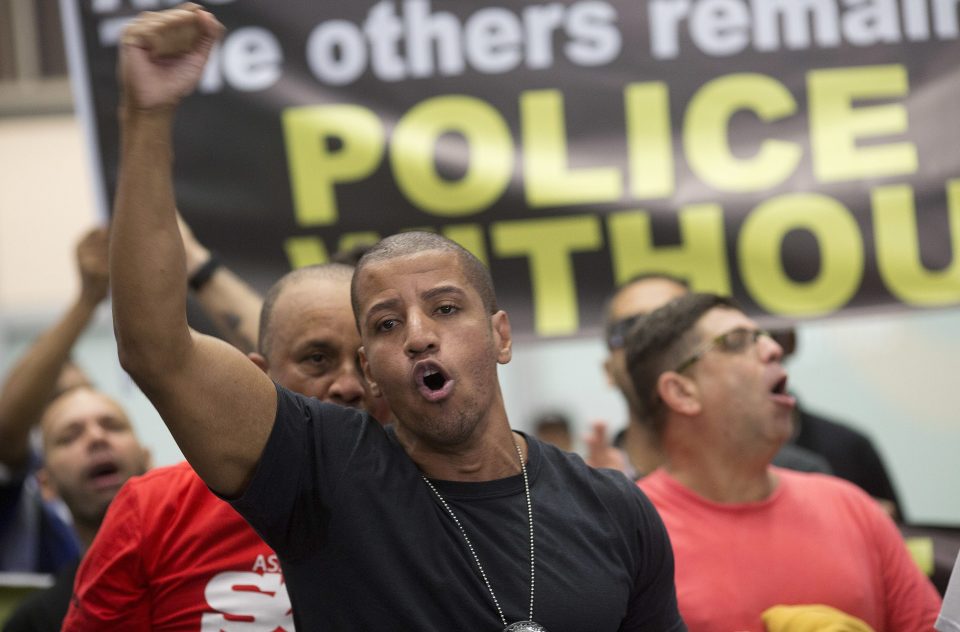 A police officer shouts slogans during the protest at the major international airport in Rio