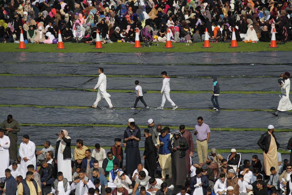  A group of men walk across mats laid down in preparation for the morning prayers