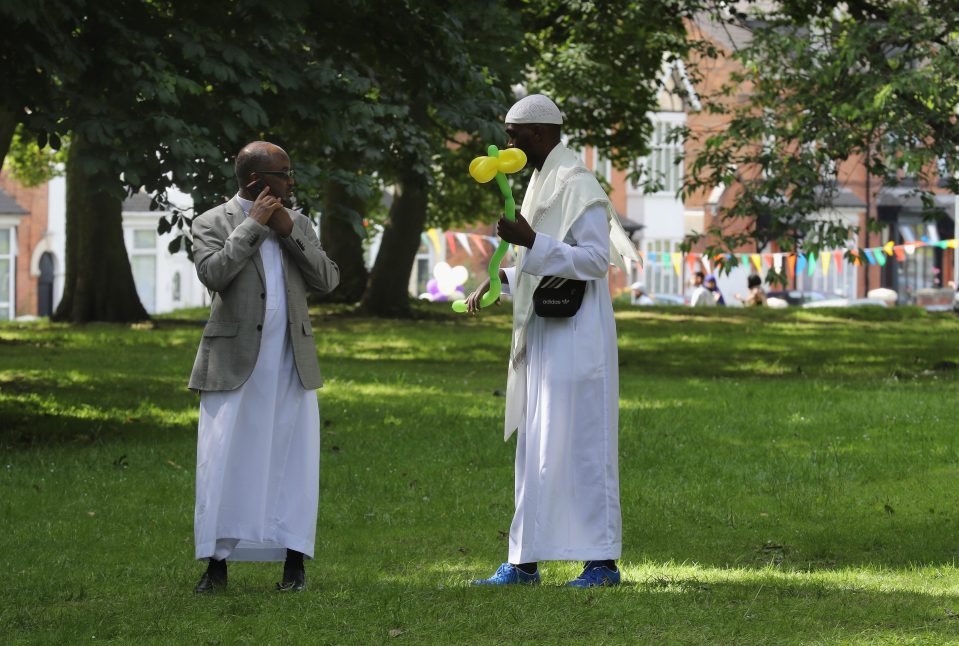  Two Muslim men chat during the Eid celebration in Birmingham today