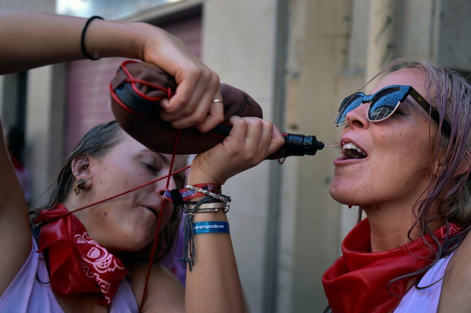  A reveller drinks from a wineskin on a day where alcohol was in plentiful supply