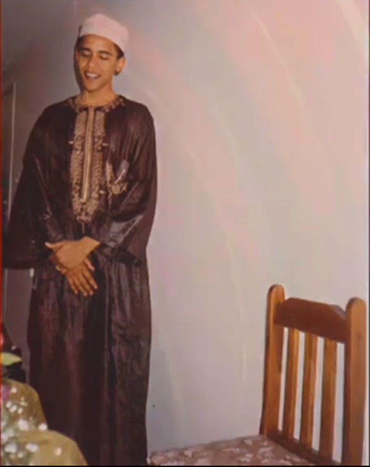  The newly released photos show Obama wearing the brown robes and a traditional cap