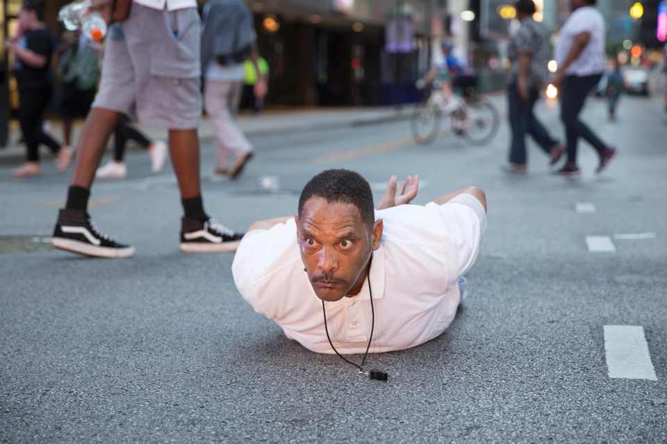  A man lays on the ground after yelling 'Don't shoot me' at police during the rally