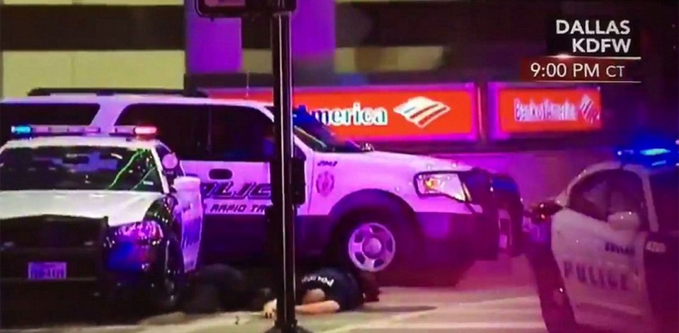  Five dead . . . A police officer, one of 11 shot by snipers, lies face down on the floor during the firefight in Dallas on Thursday