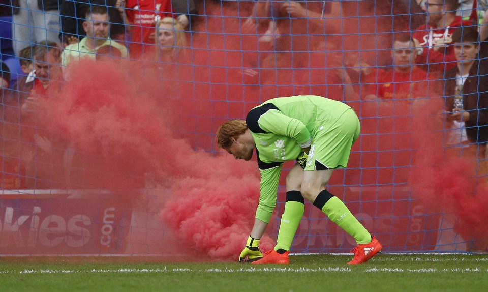 Britain Football Soccer - Tranmere Rovers v Liverpool - Pre Season Friendly - Prenton Park - 8/7/16 Liverpool's Adam Bogdan picks up a flare that was thrown onto the pitch Action Images via Reuters / Peter Cziborra Livepic EDITORIAL USE ONLY.