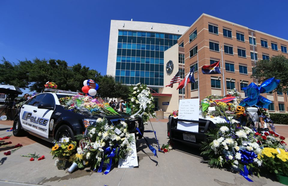  Two squad cars parked in front of Dallas Police Headquarters as a memorial for the five slain officers yesterday