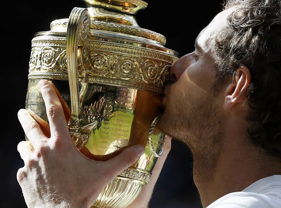  Andy Murray kisses the Wimbledon trophy after heroic win over Milos Raonic