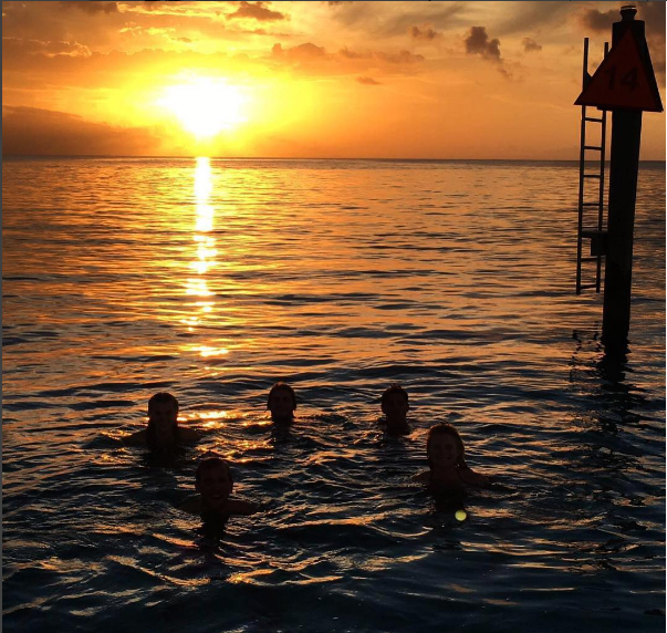  He uploaded a third pic of the stunning destination at sun-set as he fooled around in the sea with pals