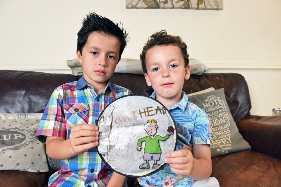  Louis and Theo, pictured with the child's toy which shows a a boy about to throw a pile of poo, with the caption 'sh*thead'