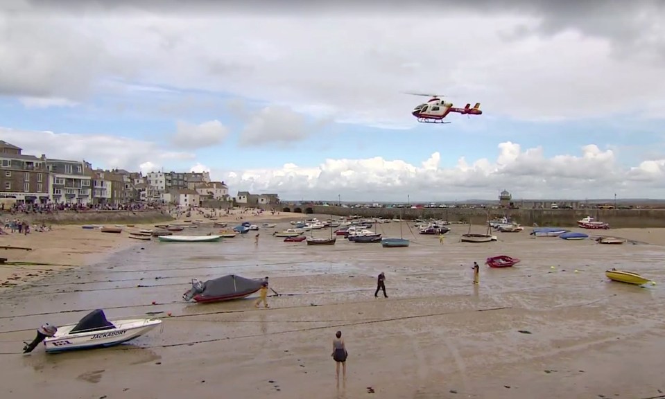  After falling from the wall the teenage girl was taken to hospital by air ambulance - pictured here arriving on the beach