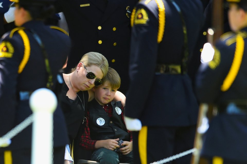  Katrina Ahrens sits with her son Magnus during the burial ceremony of her husband, Dallas Police Department Senior Corporal Lorne B. Ahrens