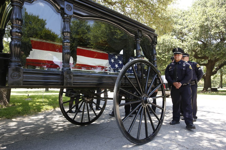  Former colleagues of the fallen hero stand near his casket before the burial ceremony