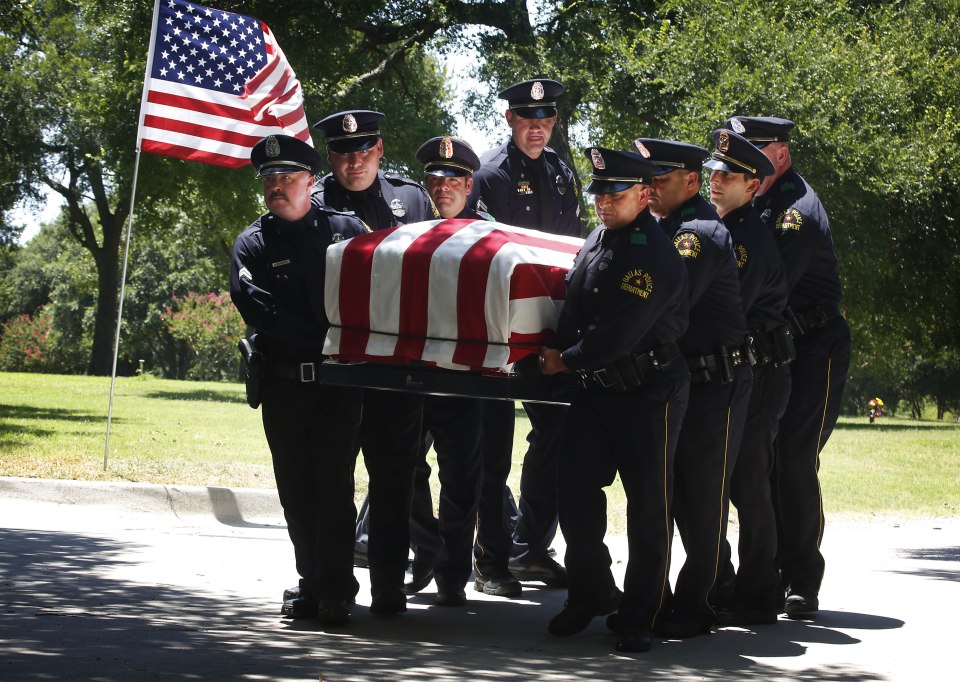  A group of Dallas police officers proudly carry the coffin of Lorne Ahrens