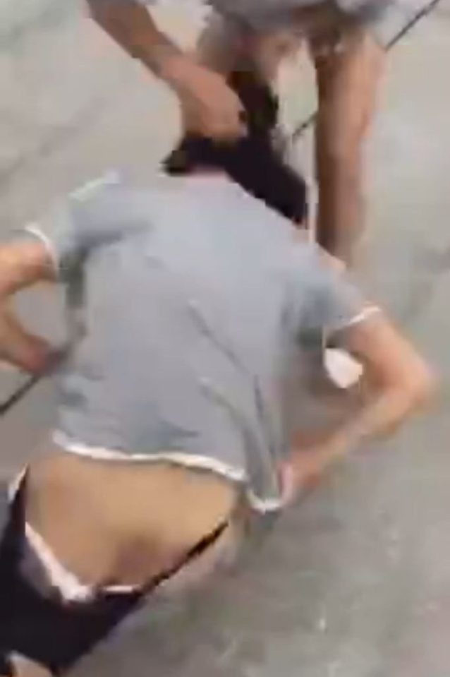 One of the attackers tries to tear the victim's clothes from her body