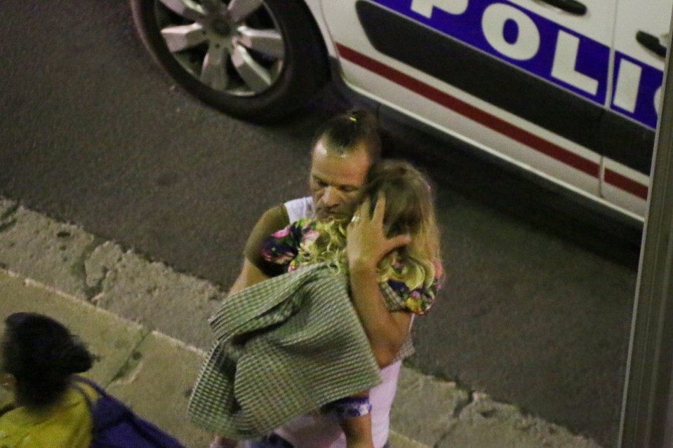  A dad cradles his young daughter as they escape the horror in Nice